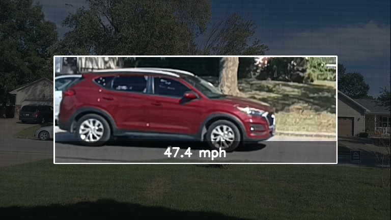 A red SUV shown as a high-resolution crop card over a dimmed street scene, captioned 47.4 mph